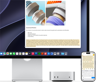 Mac mini front, tucked under Studio Display, an iPhone sits to the right of the device and the display, text selected with cut, copy, paste, and AutoFill commands above on iPhone matches highlighted text on display, showcasing Universal Clipboard
